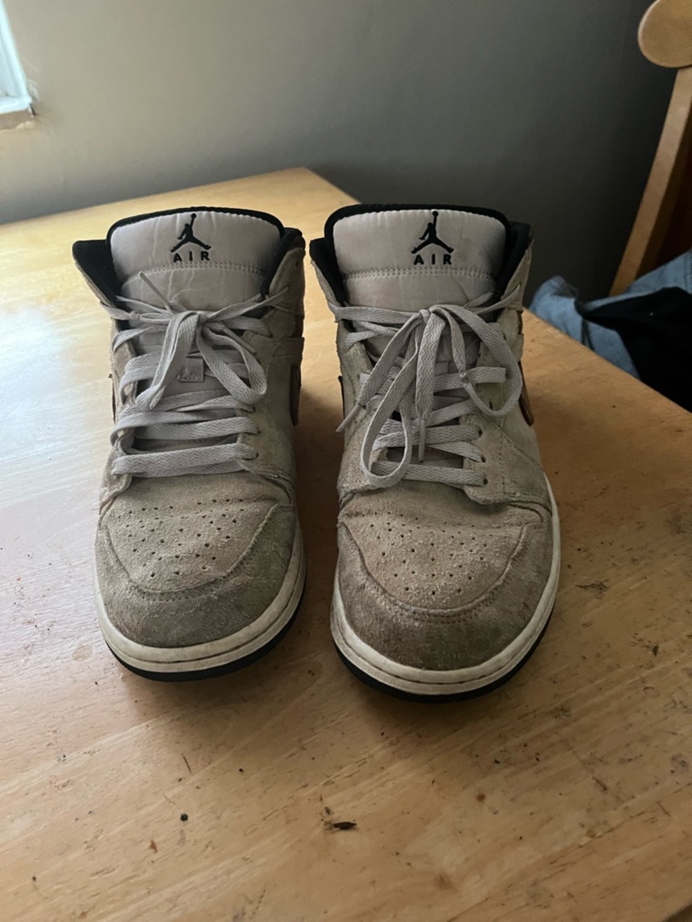 Nike Air Jordan 1 Mid shoes featuring a grey suede upper